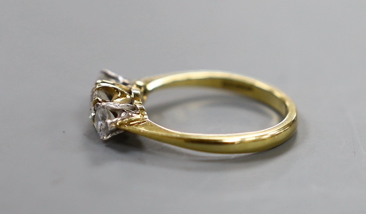 A modern 18ct gold and three stone set diamond ring, size K/L, gross weight 3 grams.